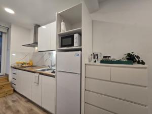 a white kitchen with a refrigerator and a microwave at Loft Centrico Tantín RH 17 in Santander +22 photos