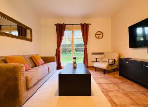 a living room with a couch and a tv at Le Vercors Park in Die