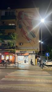 a building with a painting on the side of it at OM Center Apartments Tirana in Tirana