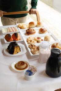 a table with several plates of pastries on it at Pousada Chão de Folhas SPA Boutique in Águas de Lindoia