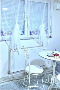 a room with a table and a chair and a window at Apartment Sekulic in Doboj +13 photos