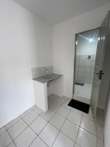 a white bathroom with a sink and a shower at Hospedagem Sousa in Santa Inês