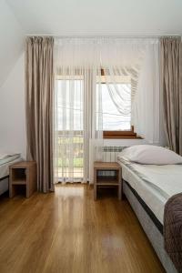 a bedroom with a bed and a large window at Pokoje gościnne u Eli i Jacka in Murzasichle
