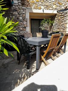 a black table and chairs in front of a stone building at La Terrette in Vagnas