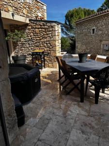 a patio with a table and chairs and a fireplace at La Terrette in Vagnas