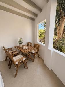 a dining room with a wooden table and chairs at NŌSSA Boutique Apartment in Naousa