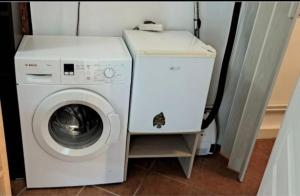 a white washer and dryer in a small room at Ptit Piment petite maison avec terrasse in Lanton