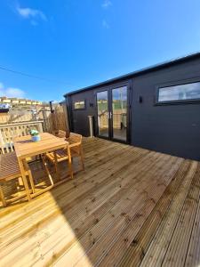 a deck with a table and chairs on a tiny house at Hillhouse Coastal Escapes - PODs in Donegal
