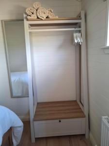 a closet with a mirror and some towels on a shelf at Hillhouse Coastal Escapes - PODs in Donegal