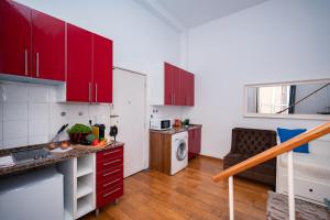a kitchen with red cabinets and a couch in a room at Large 1-Bedroom 1 Doble bed 1 Sofa bed 1 Bathroom Duplex Apartment Prime Lisbon Location in Lisbon