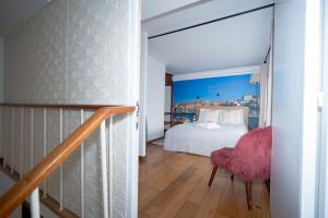 a bedroom with a bed and a chair in a room at Large 1-Bedroom 1 Doble bed 1 Sofa bed 1 Bathroom Duplex Apartment Prime Lisbon Location in Lisbon +11 photos