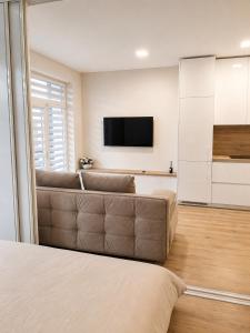 a living room with a couch and a flat screen tv at Apartment Ainiai in Panevėžys