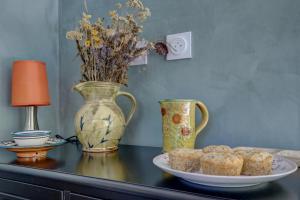 a table with a plate of muffins and a vase at Les totems de Grésigne in Penne