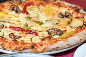 a pizza sitting on a plate on a table at Hotel de la Croix-Fédérale in Leukerbad +22 photos