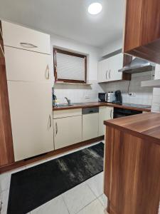 a kitchen with white appliances and wooden cabinets at Ferienwohnung Unterkunft 24 in Aldingen