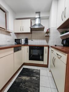 a kitchen with white cabinets and a stove top oven at Ferienwohnung Unterkunft 24 in Aldingen