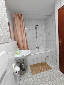 a bathroom with a sink and a bath tub at Ferienwohnung Unterkunft 24 in Aldingen