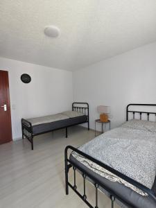 two beds in a room with white walls at Ferienwohnung Unterkunft 24 in Aldingen