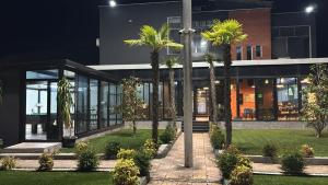 a building with palm trees in front of it at Gysi`s Hotel & Restaurant - Near Tirana in Tapizë