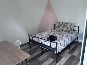 a bed in a room with a table and a table at La maison ensoleillée in Bérat