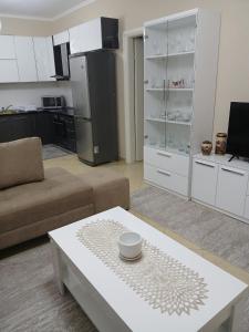 a living room with a coffee table and a kitchen at Nik's Cozy Apartment in Berat