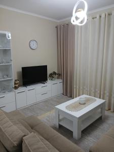 a living room with a couch and a tv at Nik's Cozy Apartment in Berat