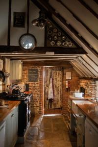 a kitchen with an open door to a brick wall at Coldharbour Cottage with Hot Tub in Stone