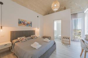 a bedroom with a bed with towels on it at Ponente & Maestro Rooms in Favignana