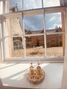 two glasses of beer sitting on a table in front of a window at Brylach Steading in Aberlour