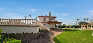 a house with a white fence and a yard at Casa Rural Los Gaspares in La Carlota