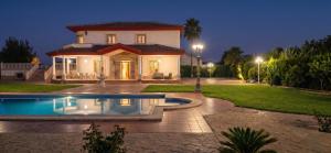a house with a swimming pool in front of it at Casa Rural Los Gaspares in La Carlota