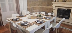 a white table with white chairs and a fireplace at Casa Rural Los Gaspares in La Carlota