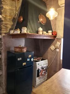 a small kitchen with a refrigerator and a stove at ZERVOU House in Batsi +24 photos