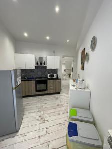 a kitchen with white cabinets and a refrigerator at Naxos Maréa Apartament in Giardini Naxos