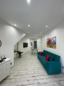 a living room with a blue couch and a tv at Naxos Maréa Apartament in Giardini Naxos