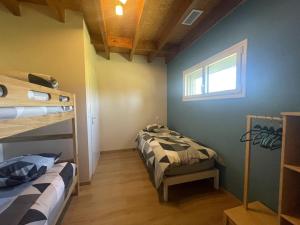 a bedroom with two bunk beds and a window at L'Atelier de Gabs in Aramits