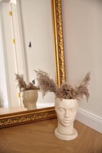 a vase sitting on a table in front of a mirror at Karma Rooms in Ternopil