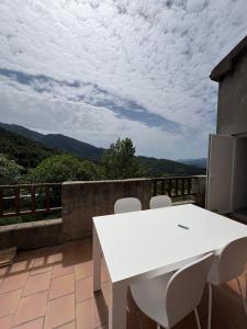 a white table and chairs on a balcony with a view at appartement olivese in Olivese