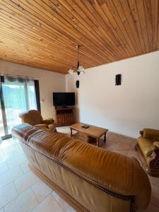 a living room with a leather couch and a table at appartement olivese in Olivese