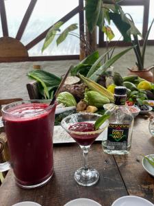 a wooden table with a drink and a bottle of alcohol at Hotel Casa Tarzan San Agustin in San Agustín