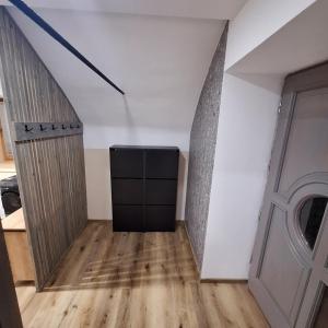 a room with white walls and wooden floors and a door at CozyNest in Kamna Gorica