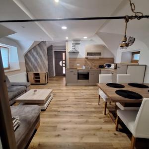 a living room with a table and a kitchen at CozyNest in Kamna Gorica
