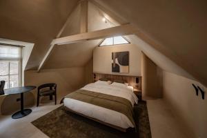 a bedroom with a bed and a table and a window at Le Diez Boutique Hotel in Den Bosch