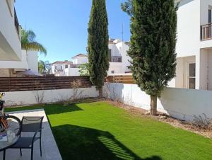 a backyard with a lawn with a table and chairs at Villa Caesar in Ayia Napa