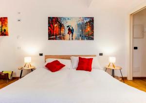 a bedroom with a white bed with two red pillows at Agri Suite with jacuzzi - La Bilaia in Lavagna