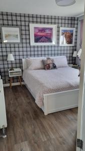 a bedroom with a white bed and paintings on the wall at Innisfail Edi - double room with private bathroom in Edinburgh +13 photos
