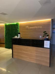 a lobby with a bar with a green wall at Hotel Porto Segur0 in Recife +12 photos