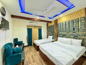 a bedroom with two beds and a blue ceiling at Rose Family Lodges in Islamabad