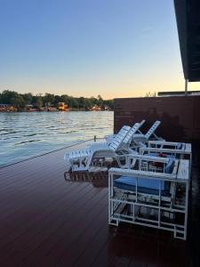 a group of chairs sitting on a dock next to the water at Dori Cottage in Ada
