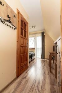 an empty room with a wooden door and a bedroom at Pokoje gościnne u Eli i Jacka in Murzasichle